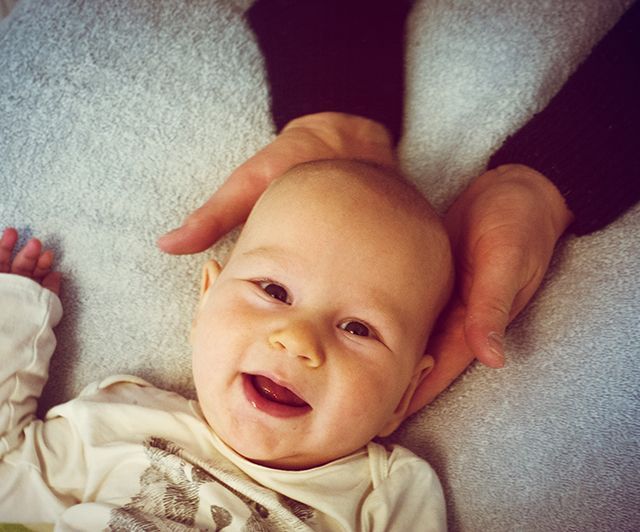 Praxis für Osteopathie und Physiotherapie Koen Vlaeyen – Baby wird mit Händen gehalten